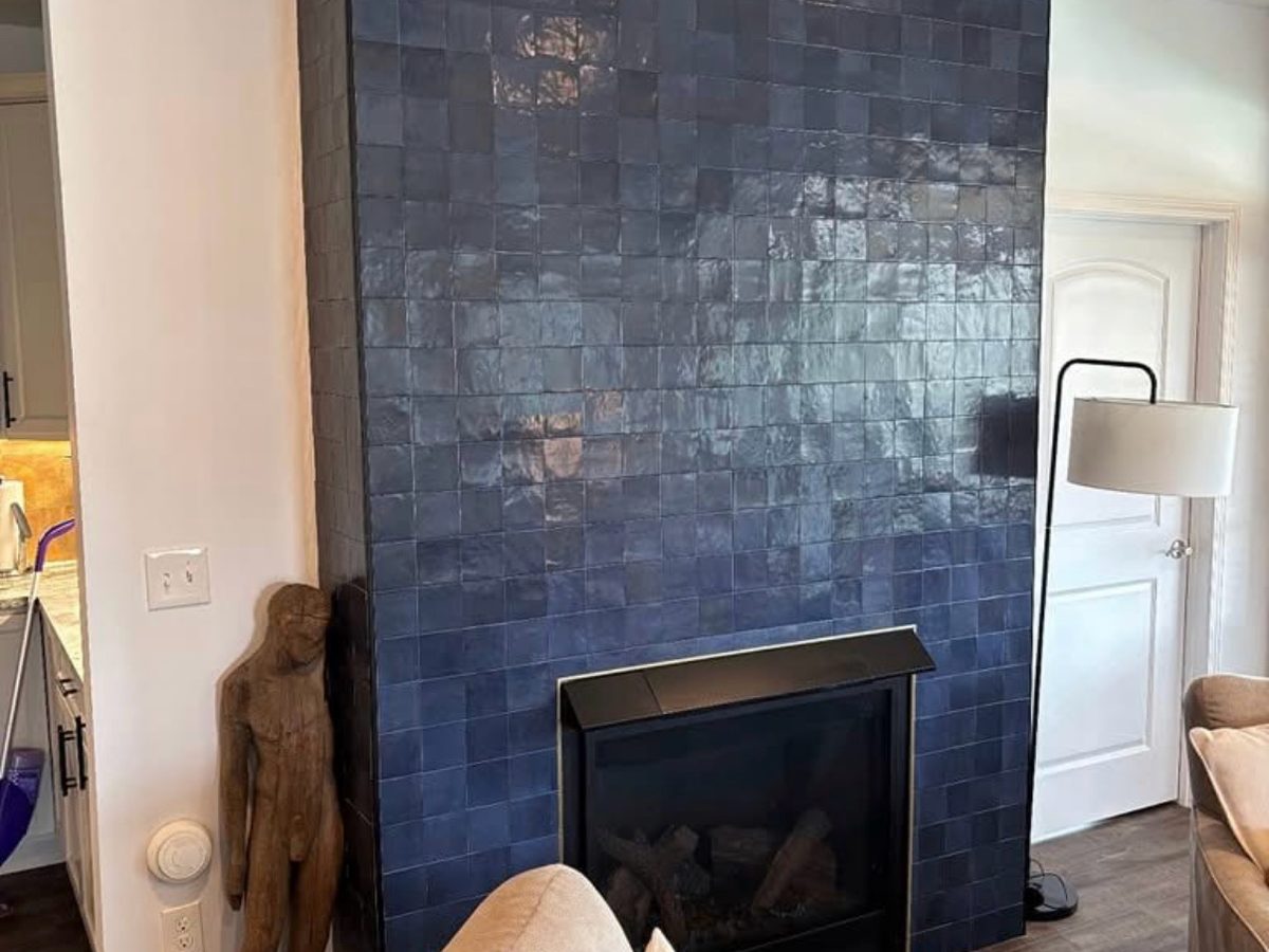 After: floor-to-ceiling fireplace surround in glossy deep blue tile